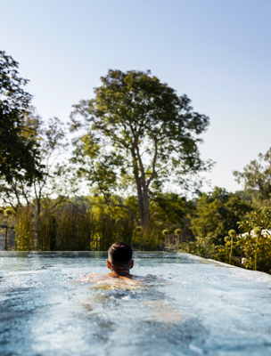 En man simmar i spats utomhuspool i skärgården