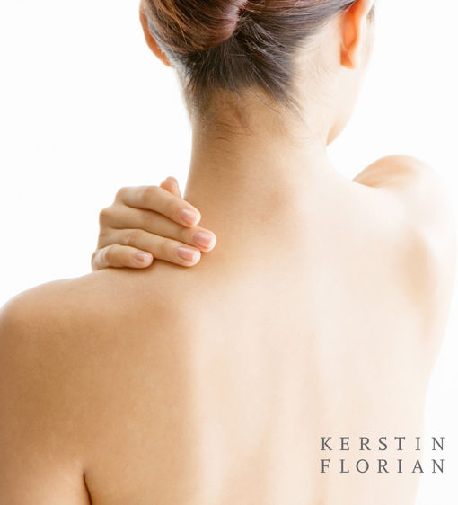 Kvinna håller handen på sin axel