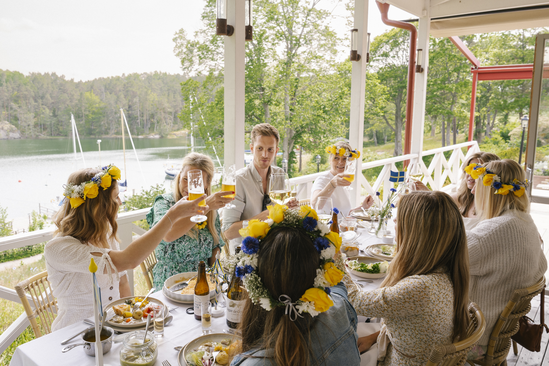 En grupp människor äter midsommarlunch och skålar