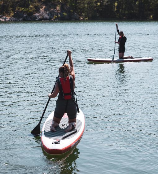 Två personer padlar SUP i viken