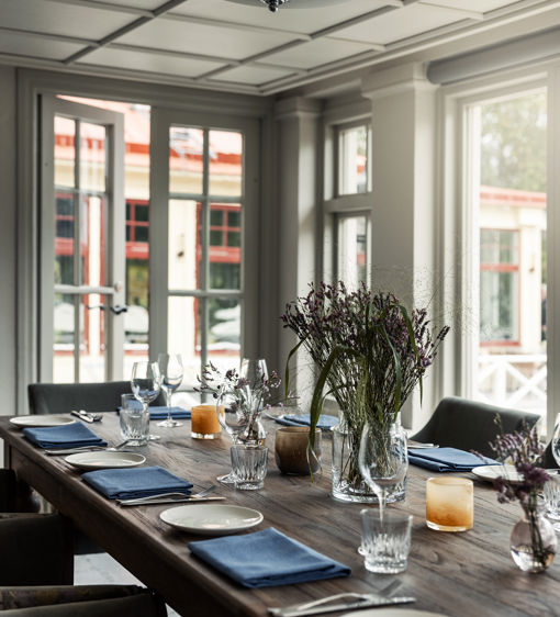 Ett stort bord uppdukat för fest i glasverandan