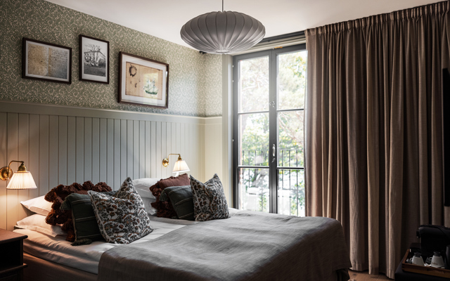 Vackert hotellrum i sobra färger och stora fönster