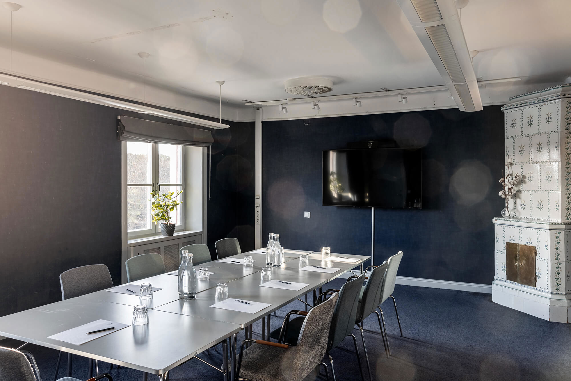 Konferenslokal i styrelsesittning med en vacker gammal kakelugn