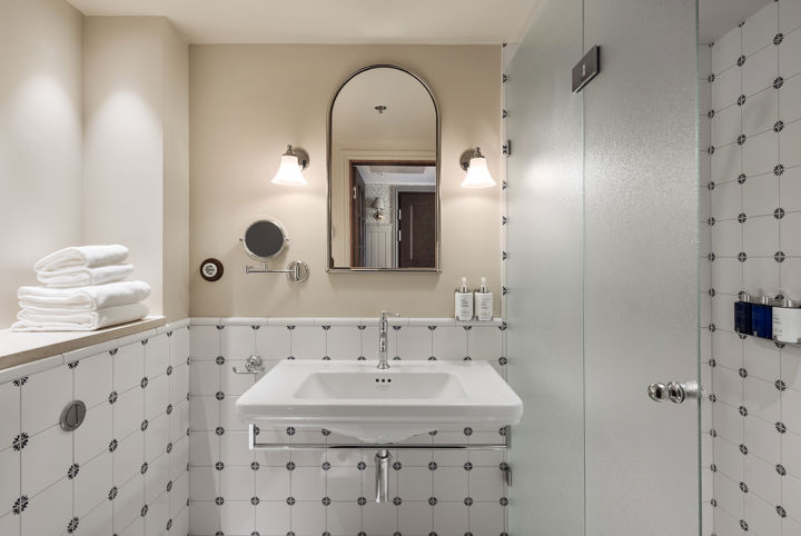 Vackert hotellbadrum med mönstrat kakel på väggarna