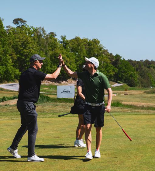 Människor gör high five på golfbana i skärgården