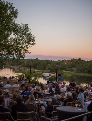 Gäster sitter på terrassen och lyssnar till kvällens konsert