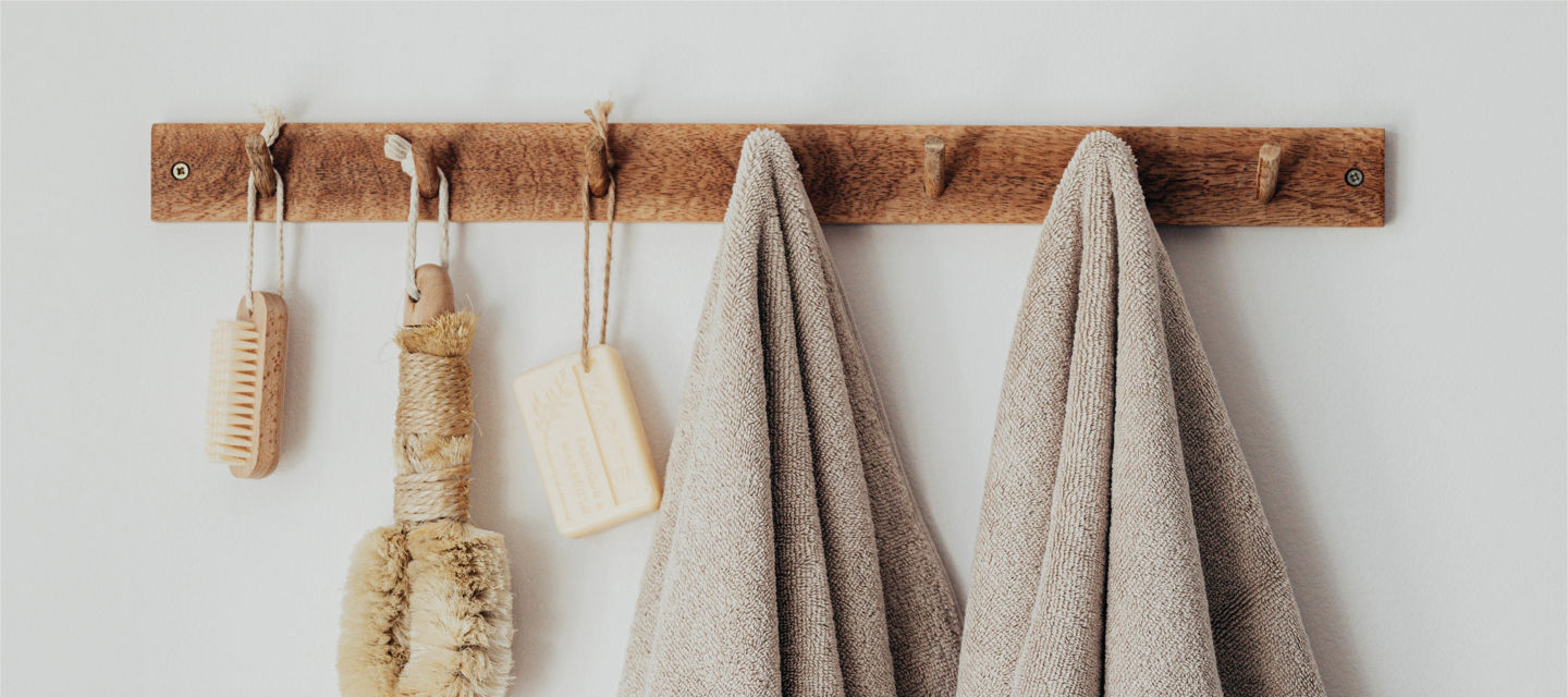 Handdukar och scrubborste hänger på krokar