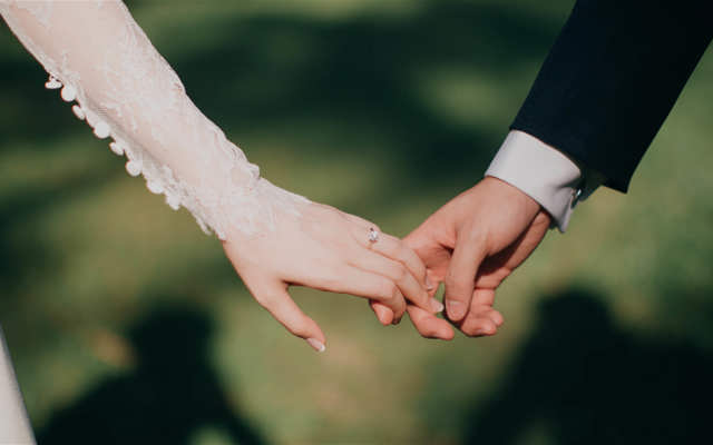 Bröllopspar håller hand