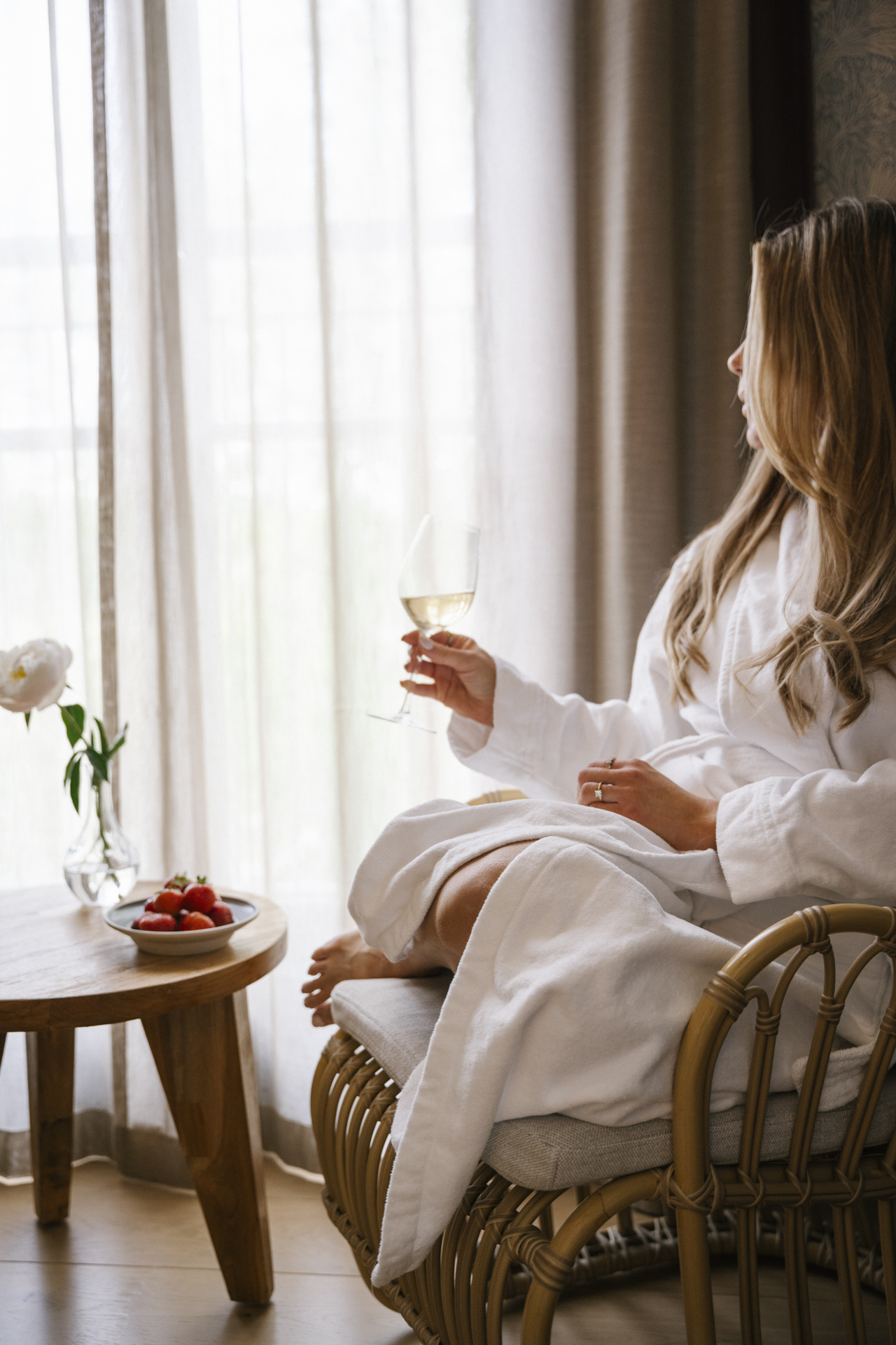 Kvinna njuter av champagne och jordgubbar på hotellrum