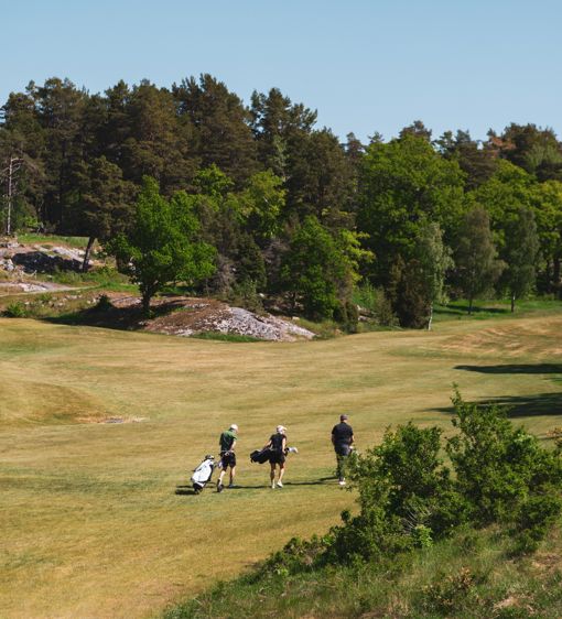 Tre personer på en golfbana