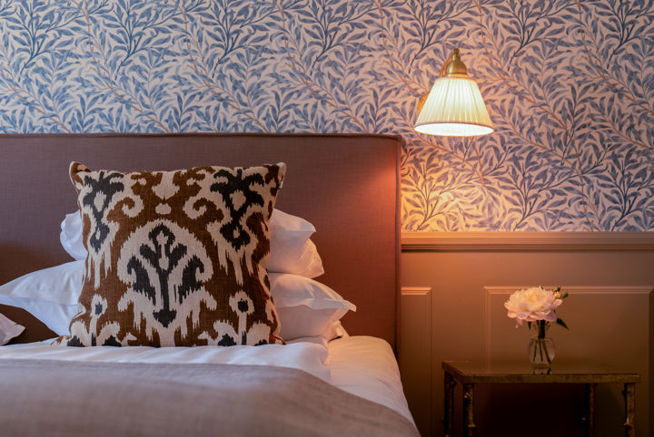 Hotellrum med blåmönstrad tapet och ljusa sobra färger