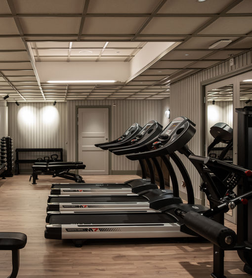 Välutrustat hotellgym med löpband och styrkemaskiner