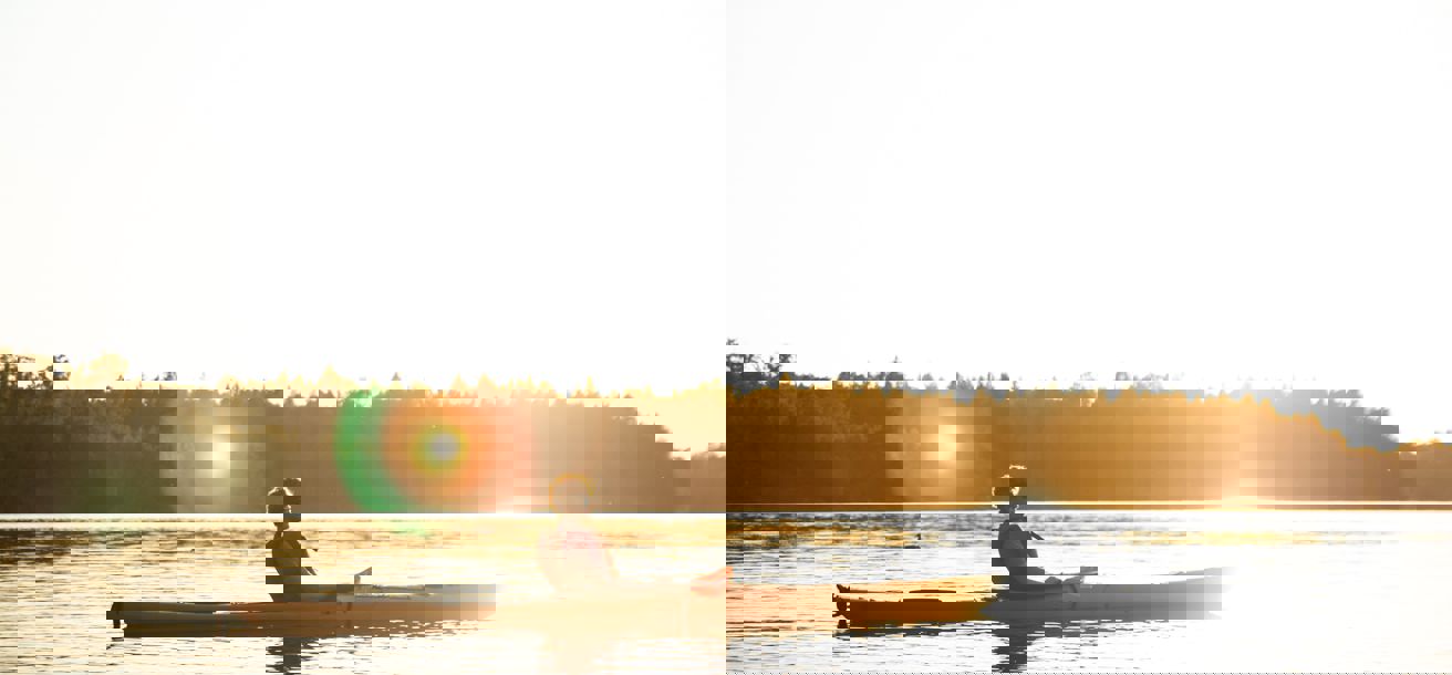 En person paddlar kajak i soluppgången