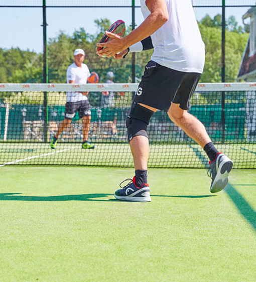 Två personer spelar padel utomhus