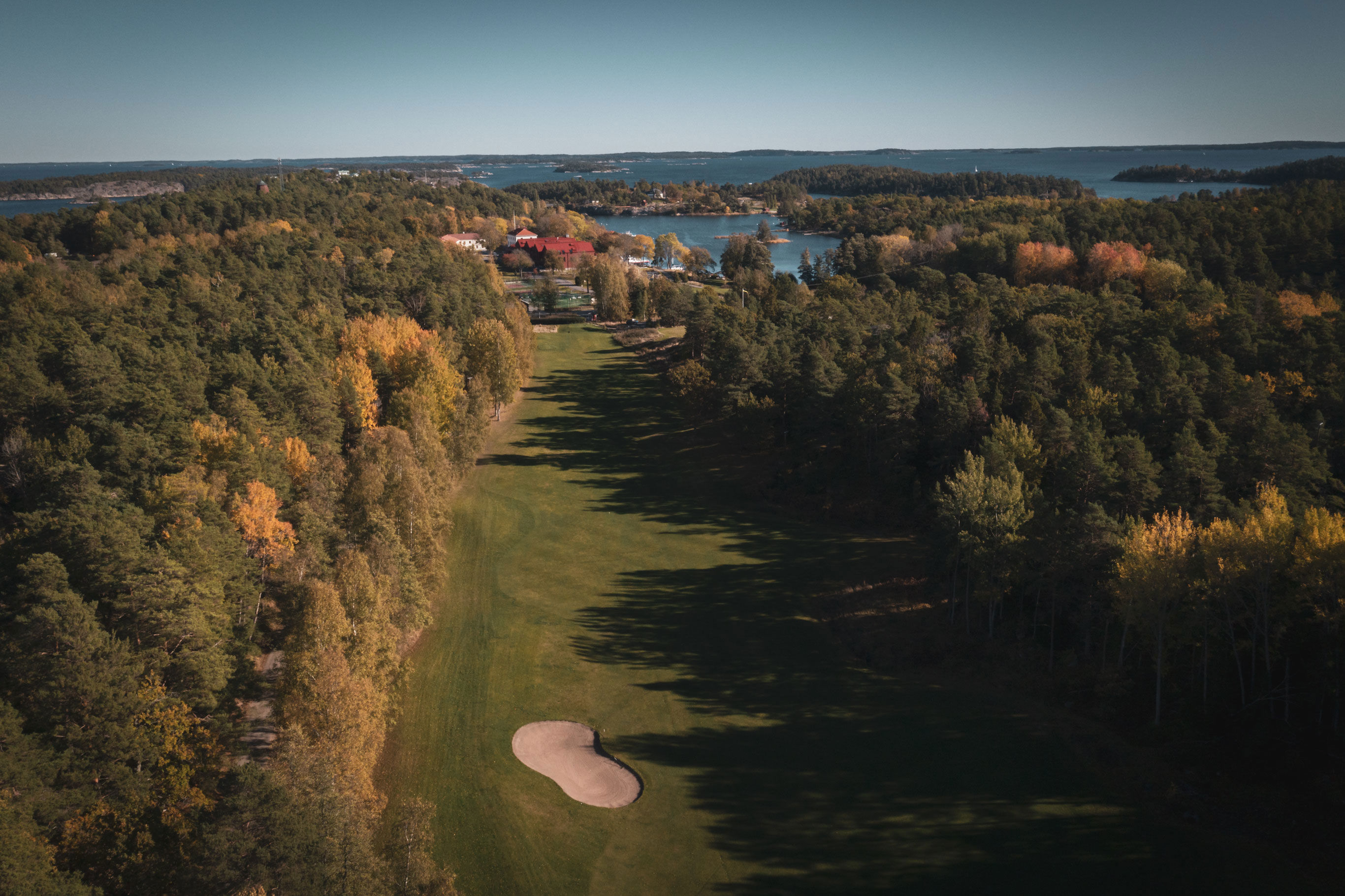Drönarbild över golfbana nära havet i skärgården