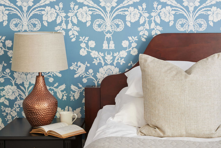 Vacker blå tapet och en skön säng