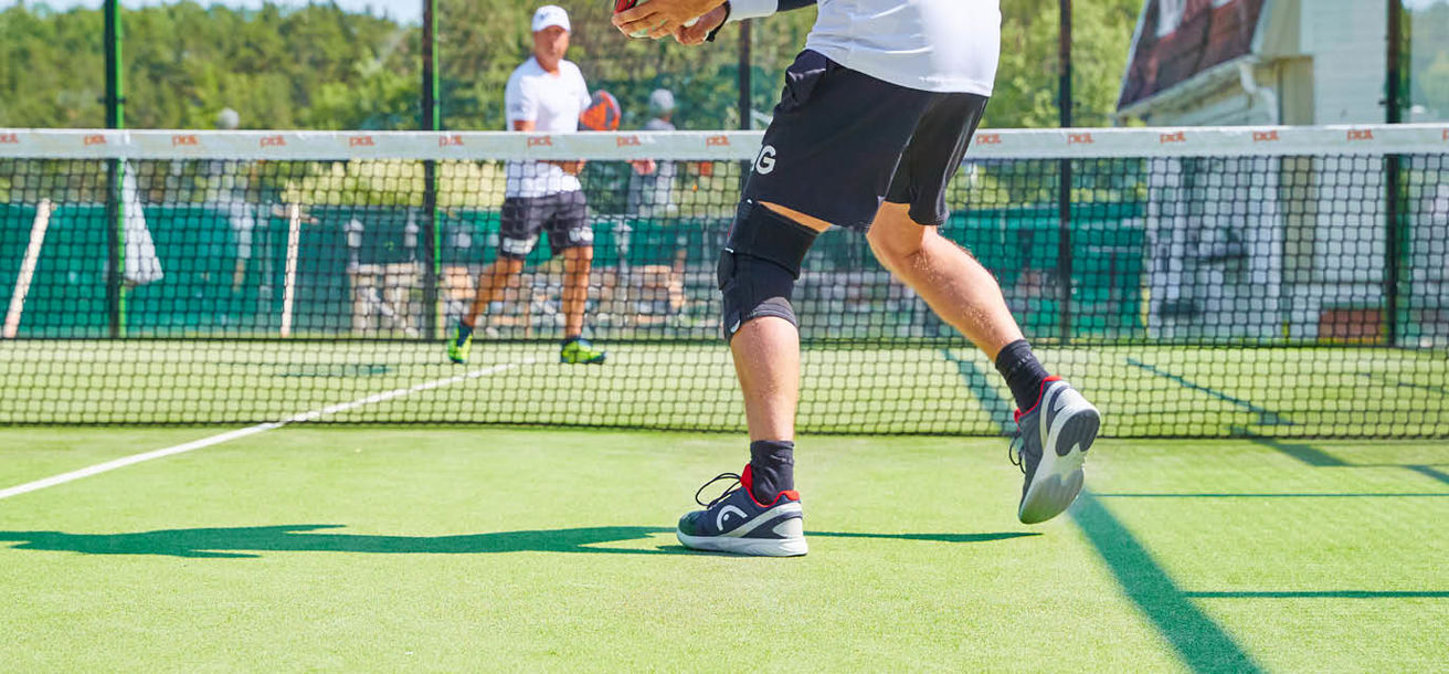 Två personer spelar padel utomhus
