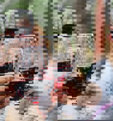 Människor skålar i rödvin