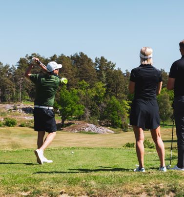 Tre personer på en golfbana